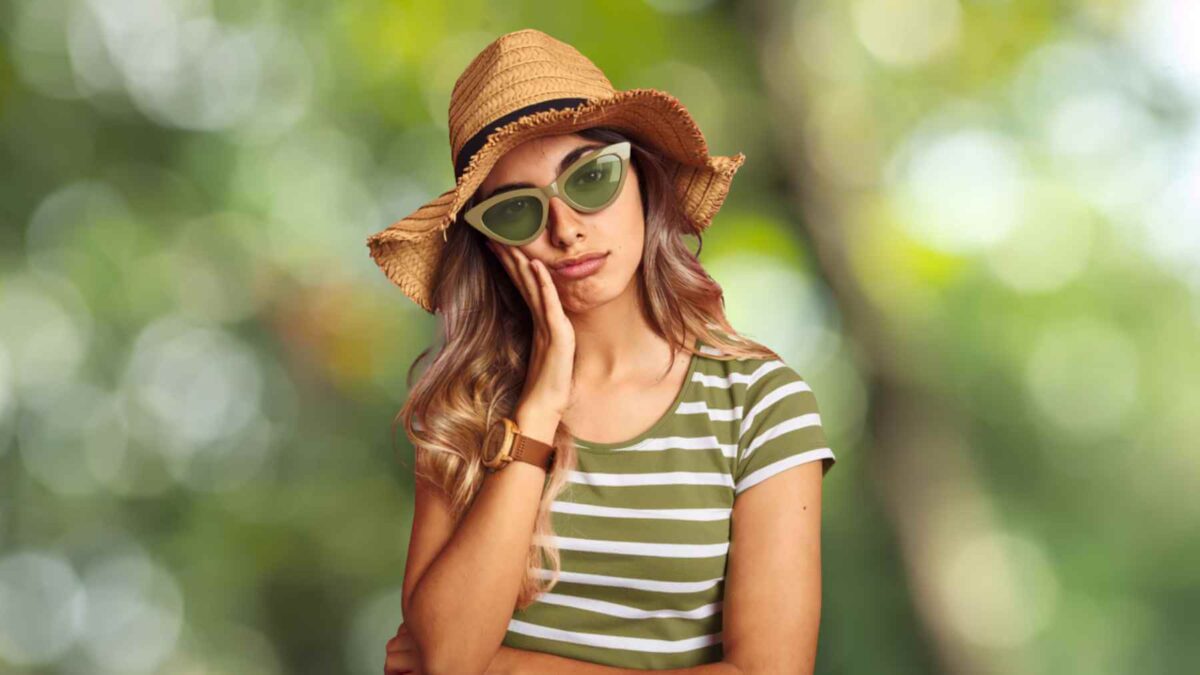 unhappy-woman-wearing-shit-coloured-glasses-1800-sm A person wearing shit-coloured sunglasses stands outdoor looking sad and unimpressed, hinting at the lingering effects of trauma and CPTSD.