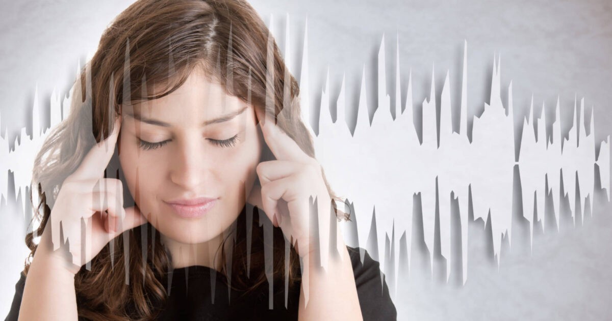 A woman with closed eyes touches her temples, sound waves visually depicted around her head, as if she's trusting her intuition deeply.